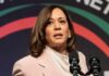 Kamala Harris speaking at an event, microphones in front.