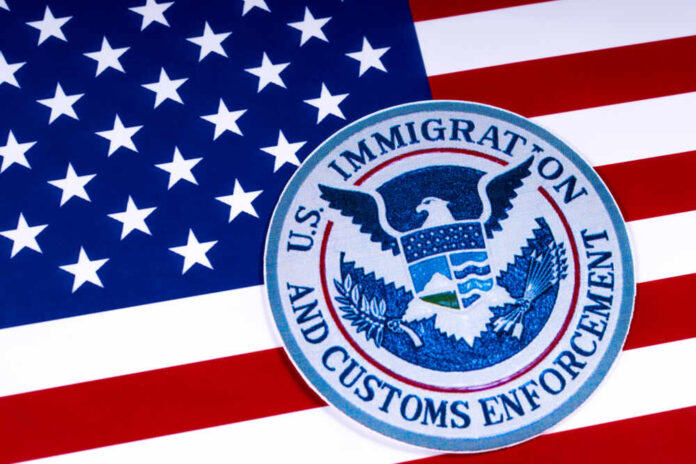 shutterstock_1055129177.jpg featured image US Immigration and Customs Enforcement badge on flag