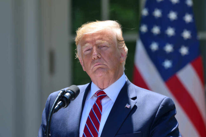 shutterstock_1432764869.jpg featured image Donald Trump speaking with US flag in the back.