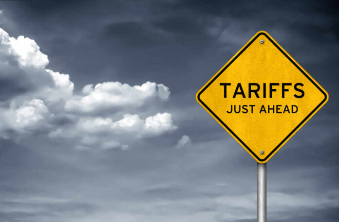 shutterstock_1037228893.jpg featured image Yellow sign saying tariffs just ahead cloudy sky