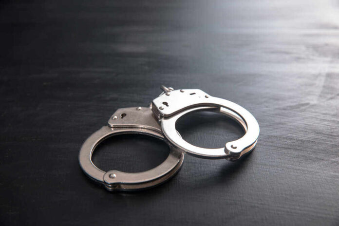 shutterstock_1857504991.jpg featured image Metal handcuffs on a dark textured surface.