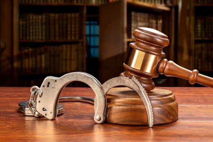 shutterstock_2052225677.jpg featured image Wooden gavel and handcuffs on a table.