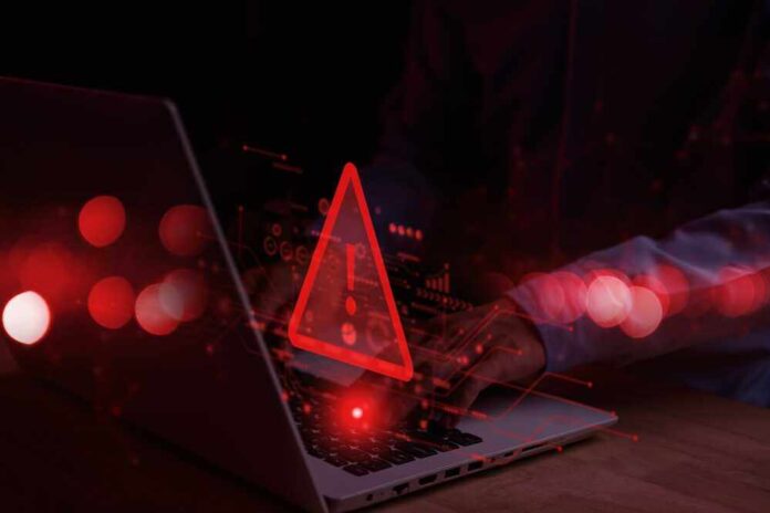 shutterstock_2248466625.jpg featured image Warning symbol over laptop with user.