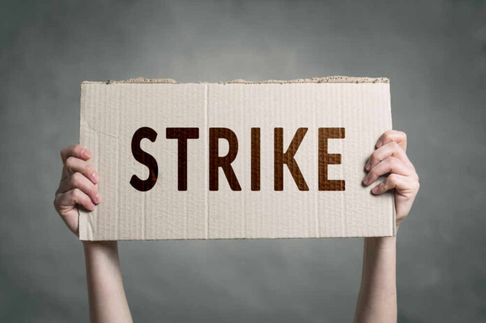 shutterstock_683350906.jpg featured image Two hands holding cardboard sign with strike text