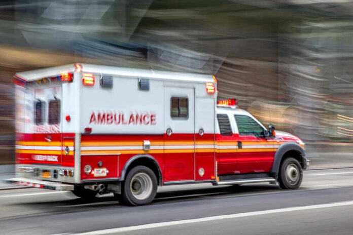 shutterstock_1495131698.jpg featured image Red and white ambulance driving on a city street.