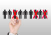 Hand crossing out stick figures with red marker