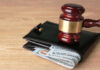 Gavel on wallet with visible dollar bills