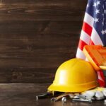 Yellow hard hat and tools with American flag.