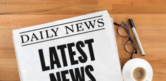 Newspaper with headline latest news on table
