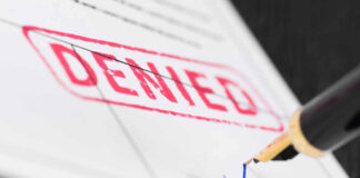 Denied stamp and pen signing document