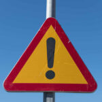 Triangular warning sign with exclamation mark.