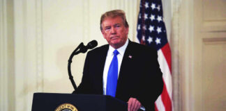 Donald Trump speaking at podium.