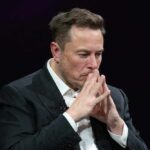 Elon Musk in suit thinking.