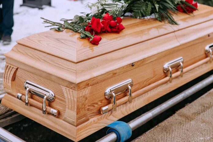 shutterstock_2423034429.jpg featured image Wooden casket with red roses on top