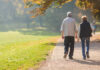 Two people walking together on a park path.