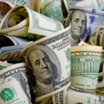 Rolled U.S. dollar bills in various denominations.