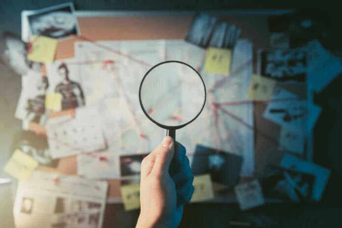 Magnifying glass over investigation board with photos and strings
