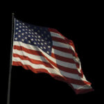 End of an Era: Conservative Giant Passes American flag waving against a black background