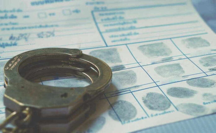 shutterstock_2291869477.jpg Handcuffs on a fingerprint document