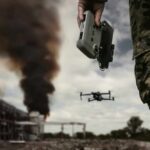 Drone commanded by military personnel holding a controller