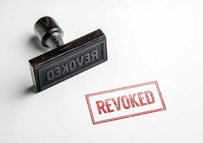 Wooden stamp next to red revoked text stamp