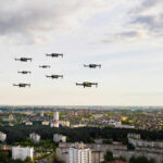 Drones flying over a cityscape under cloudy sky