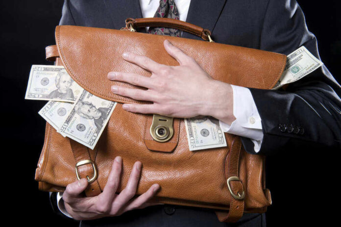 Person holding briefcase with money protruding from it