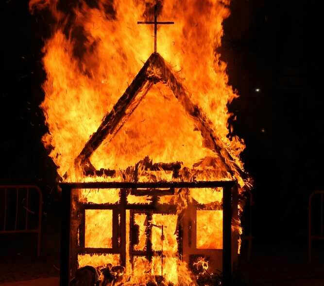 shutterstock_504285700.jpg Wooden church structure burning with bright flames at night
