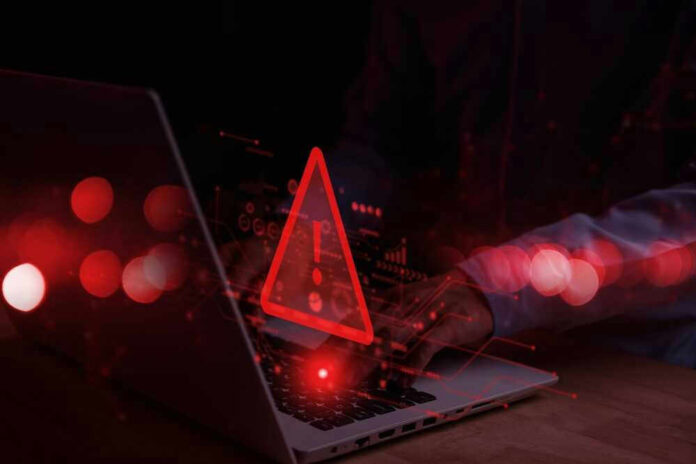 Warning symbol over laptop with user