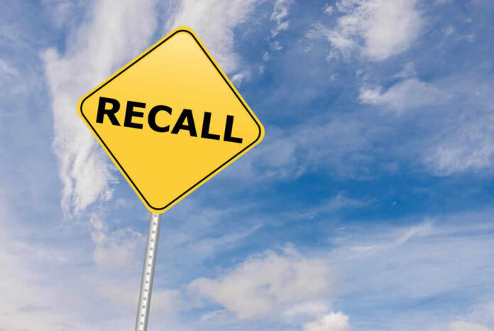 Yellow sign with RECALL text against blue sky