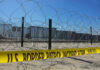 Border patrol tape and barbed wire fence.