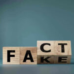 Wooden blocks displaying FACT and FAKE juxtaposed.