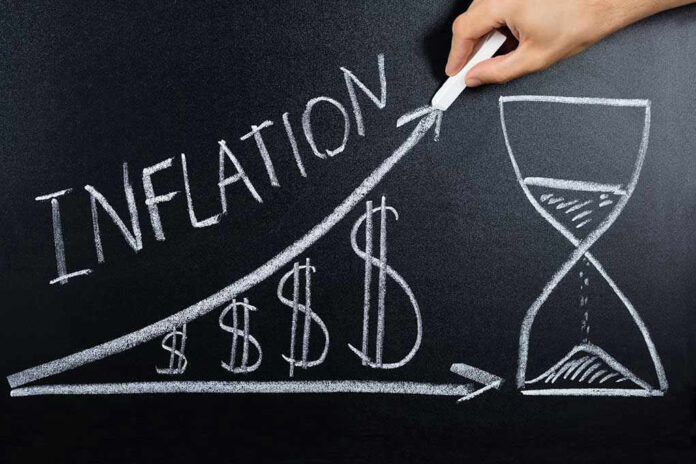 Chalkboard drawing of inflation with rising dollar symbols.