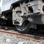 Close-up view of a train wheel on railway tracks