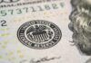 Close-up of a United States dollar bill featuring the Federal Reserve emblem