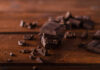 Stack of dark chocolate pieces on a wooden surface