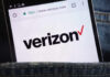 Close-up of a smartphone displaying the Verizon website logo in a denim pocket