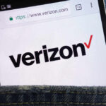 Close-up of a smartphone displaying the Verizon website logo in a denim pocket
