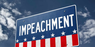 A sign displaying the word 'IMPEACHMENT' against a cloudy sky