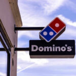 Dominos Pizza store sign with blue sky background