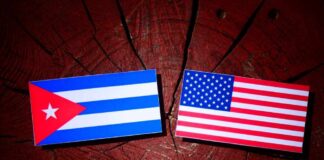 Cuban and American flags placed on a wooden surface