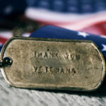 Dog tag and American flag honoring veterans.