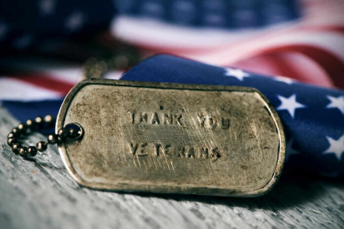 Dog tag and American flag honoring veterans.