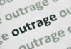 Close-up of the word 'outrage' printed in bold on paper