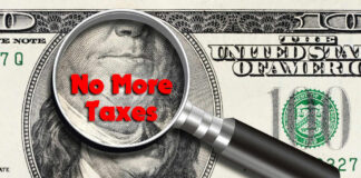 Magnifying glass over hundred dollar bill no taxes