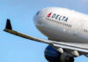 Delta airplane in flight with blue sky background.