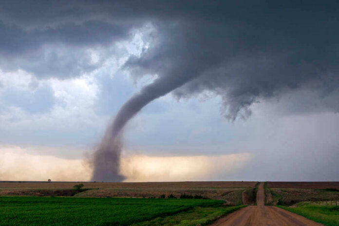 Tornado touching down in an open field area.
