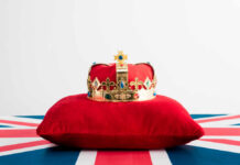 Here Comes the King! A royal crown resting on a red velvet pillow with a British flag background