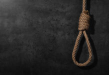 A noose made of rope hanging against a dark textured background