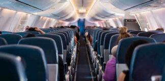 Airplane interior with passengers seated mid-flight.